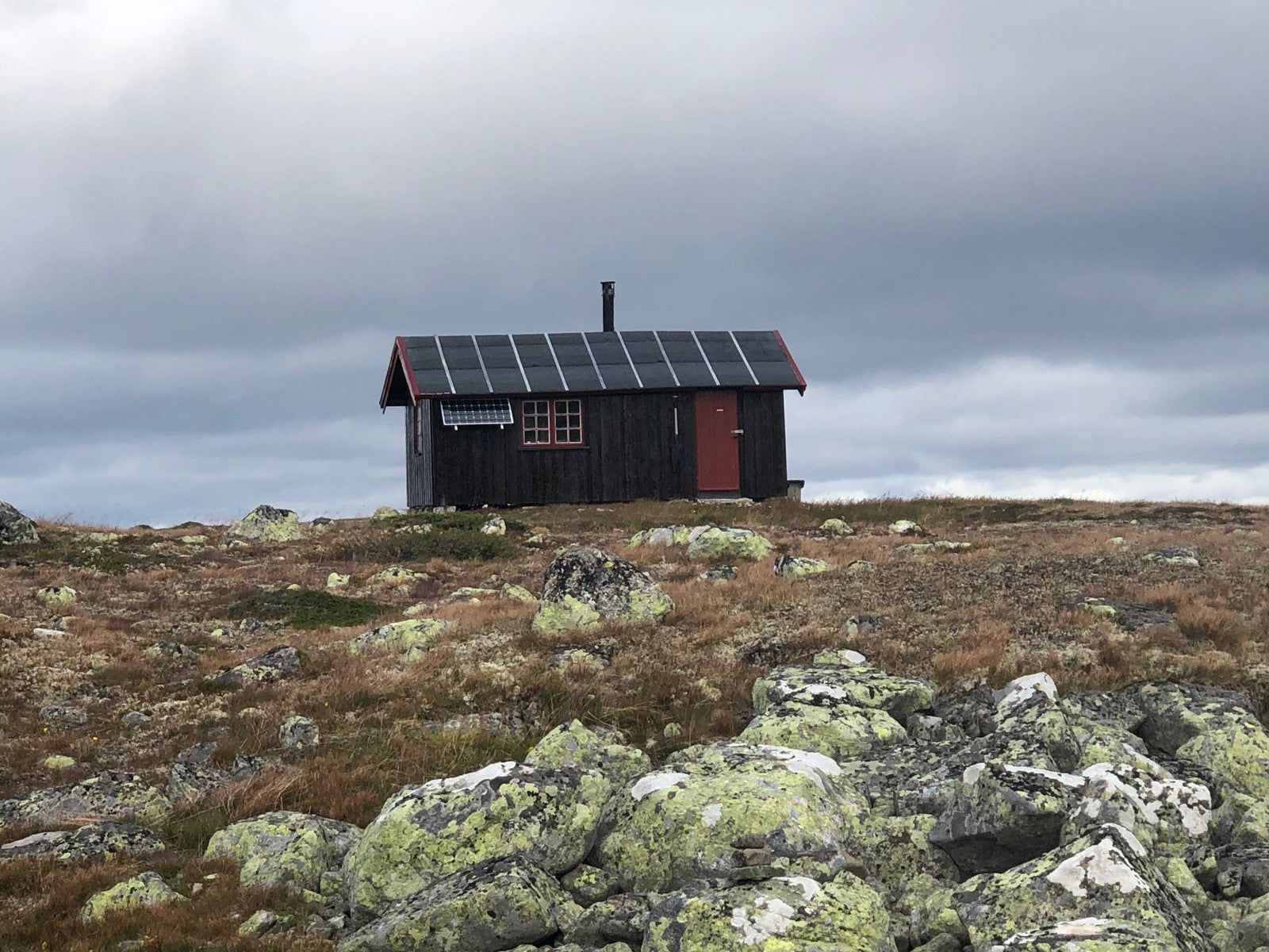 Jutulsbu alene på den steinete vidda under en tung grå himmel