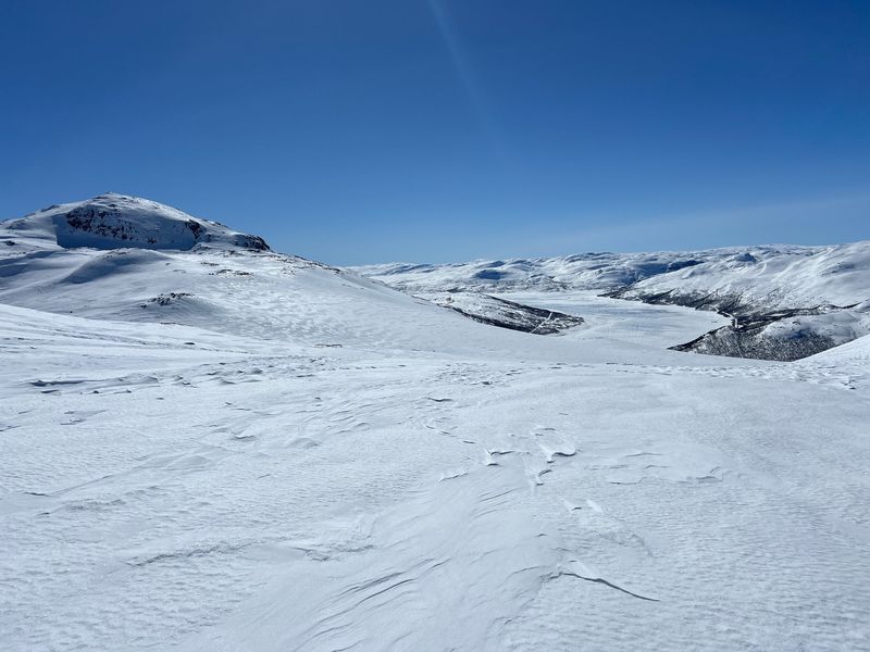 Snødekt høyfjell med Tullstøyltjønnane bak, sett fra Jutulsbu en klar vinterdag