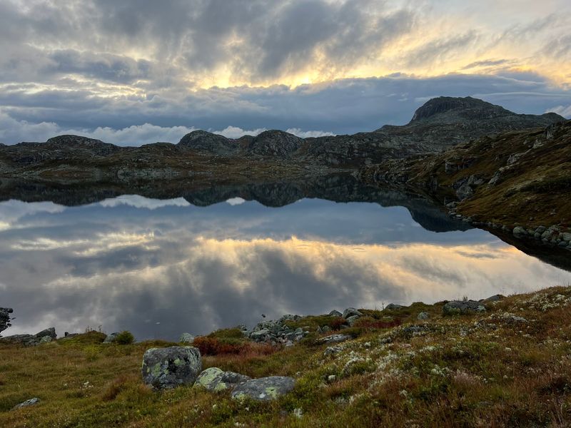 Såtetjønn blikkstille i kveldslys, med skyene speilet i vannflaten