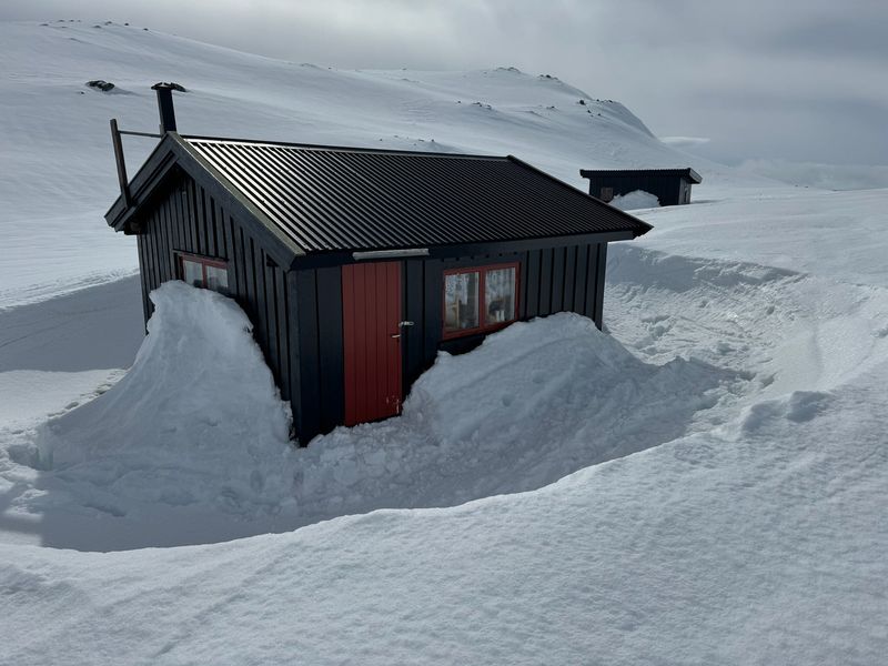 Trollheimen nesten begravd i snø, med bare taket og en snøryddet inngang synlig